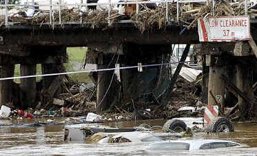 COMMUNITY DEVASTATION: Cars and debris stack up against the railway bridge in Grantham on January 12, two days after the flood. COMMUNITY DEVASTATION: Cars and debris stack up against the railway bridge in Grantham on January 12, two days after the flood.